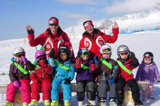Amden Schweizer Skischule Kinder und Lehrer winken im Kinderland Arvenbüel